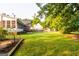 Lush backyard featuring a fenced yard, mature trees, well-manicured lawn, and a wooden garden plot with soil at 30 Carolyn Ct, Social Circle, GA 30025