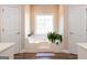 Bright bathroom with a large tub surrounded by windows and accented with dual white doors at 30 Carolyn Ct, Social Circle, GA 30025