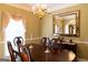 Well-lit dining room featuring a beautiful window, a dark wood table with seating, and a chandelier overhead at 30 Carolyn Ct, Social Circle, GA 30025