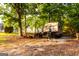 Gravel driveway features camper, ATV, and other equipment parked under the shade of trees at 30 Carolyn Ct, Social Circle, GA 30025