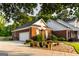 Brick home with a two-car garage featuring mature landscaping and a lamp post at 30 Carolyn Ct, Social Circle, GA 30025