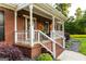 Charming brick home featuring a welcoming front porch with white railings and meticulously landscaped yard at 30 Carolyn Ct, Social Circle, GA 30025