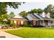 Charming brick home featuring a covered front porch and lush green lawn with mature trees at 30 Carolyn Ct, Social Circle, GA 30025