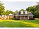 Charming brick home featuring a covered front porch and lush green lawn with mature trees at 30 Carolyn Ct, Social Circle, GA 30025