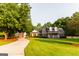 Charming brick home featuring a covered front porch and lush green lawn with mature trees at 30 Carolyn Ct, Social Circle, GA 30025