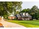 Charming brick home featuring a covered front porch and lush green lawn with mature trees at 30 Carolyn Ct, Social Circle, GA 30025
