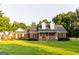 Charming brick home featuring a covered front porch and lush green lawn with mature trees at 30 Carolyn Ct, Social Circle, GA 30025