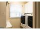Clean laundry room with white cabinets, a window with blinds and modern appliances at 30 Carolyn Ct, Social Circle, GA 30025