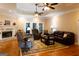 Comfortable living area featuring a ceiling fan, hardwood floors, a cozy seating arrangement, and backyard access at 30 Carolyn Ct, Social Circle, GA 30025
