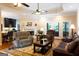 Inviting living room with hardwood floors, a cozy fireplace, ceiling fans, and access to the backyard at 30 Carolyn Ct, Social Circle, GA 30025