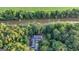 Aerial view of the house surrounded by lush trees with a river nearby and a green field in the background at 223 Old Rome Rd, Kingston, GA 30145
