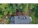 Bird's eye view of the home highlighting the deck, umbrella covered table, landscaping, roofline and wooded setting at 223 Old Rome Rd, Kingston, GA 30145
