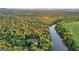 Aerial view showing a beautiful home nestled amongst green trees next to a river and grassy field on the other side at 223 Old Rome Rd, Kingston, GA 30145