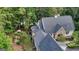 Aerial view showcasing the house's stone accents, architectural roof line, lush landscaping, and wooded privacy at 223 Old Rome Rd, Kingston, GA 30145
