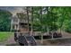 Back exterior of the home with a spacious deck with steps and serene, forested surrounding, enhancing the outdoor experience at 223 Old Rome Rd, Kingston, GA 30145