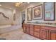 Bathroom with wood cabinets, double vanity, soaking tub, tiled floor, and decorative mirrors at 223 Old Rome Rd, Kingston, GA 30145