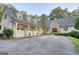 Charming home features a stone facade, three-car garage, and a circular driveway surrounded by lush landscaping at 223 Old Rome Rd, Kingston, GA 30145