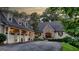 Charming home features a stone facade, three-car garage, and a circular driveway surrounded by lush landscaping at 223 Old Rome Rd, Kingston, GA 30145