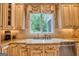 Kitchen sink area with granite countertop, white cabinetry, and a view of lush greenery at 223 Old Rome Rd, Kingston, GA 30145