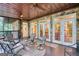 Covered porch with ceiling fans and an outdoor seating area with several doors to the home at 223 Old Rome Rd, Kingston, GA 30145
