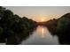 A scenic view of the river as the sun sets, framed by lush green trees and reflecting the sunlight on the water at 223 Old Rome Rd, Kingston, GA 30145