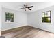 Bright bedroom featuring wood floors, ceiling fan, and two large windows that offer plentiful natural light at 110 Long Leaf, Peachtree City, GA 30269