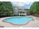 Inviting in-ground pool surrounded by a concrete patio and lush greenery in the backyard at 1979 Alcovy Shoals Blf, Lawrenceville, GA 30045