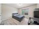 Bedroom featuring wood-look flooring, a window with blinds, and a comfortable bed at 1979 Alcovy Shoals Blf, Lawrenceville, GA 30045