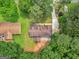 Aerial view showcases the roofline of this house with a long driveway and mature trees at 90 Country Roads Cir, Stockbridge, GA 30281
