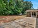 Large backyard featuring mature trees, a concrete patio, and sunroom addition at 90 Country Roads Cir, Stockbridge, GA 30281