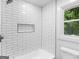 Modern shower with white subway tiles, built-in shelf, natural light, and black shower fixtures at 90 Country Roads Cir, Stockbridge, GA 30281