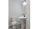 A half bathroom with black and white patterned tiles, a pedestal sink, and a modern light fixture at 90 Country Roads Cir, Stockbridge, GA 30281