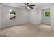 A bright bedroom features neutral carpet, two windows providing natural light, and a ceiling fan at 90 Country Roads Cir, Stockbridge, GA 30281