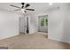 A well-lit bedroom with neutral carpet, ceiling fan, two windows, and access to an ensuite bathroom at 90 Country Roads Cir, Stockbridge, GA 30281