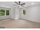 Bright bedroom boasts neutral carpet, two windows offering natural light, a ceiling fan, and a closet at 90 Country Roads Cir, Stockbridge, GA 30281