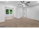 Open bedroom with neutral carpet, a ceiling fan, a window and walk-in closet, showcasing ample space at 90 Country Roads Cir, Stockbridge, GA 30281