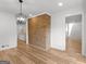 Dining room with a brick accent wall, modern light fixture, and light-colored wood floors at 90 Country Roads Cir, Stockbridge, GA 30281