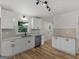 Updated kitchen boasts white cabinets, stainless steel appliances, subway tile backsplash, and hardwood floors at 90 Country Roads Cir, Stockbridge, GA 30281