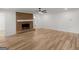 Bright living room with a brick fireplace, modern ceiling fan, and light wood floors at 90 Country Roads Cir, Stockbridge, GA 30281