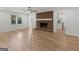 Living room features a brick fireplace, modern ceiling fan, large windows, and light wood floors at 90 Country Roads Cir, Stockbridge, GA 30281