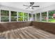 Bright sunroom features a ceiling fan, hardwood floors, and a brick accent wall with large windows to enjoy the view at 90 Country Roads Cir, Stockbridge, GA 30281