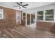 Sunroom with brick accents, wood floors, ceiling fan, and access to kitchen and outdoor patio at 90 Country Roads Cir, Stockbridge, GA 30281