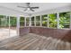 Sunroom features a ceiling fan, wood floors, brick accents, and lots of bright light streaming in from the large windows at 90 Country Roads Cir, Stockbridge, GA 30281