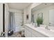 Bright bathroom features a double vanity, and a shower-tub combo with a curtain at 5455 Baybrook Cir, South Fulton, GA 30349
