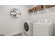 Well-lit laundry room with modern white washer and dryer, complemented by overhead storage at 5455 Baybrook Cir, South Fulton, GA 30349