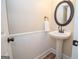 Stylish half-bath with pedestal sink, elegant mirror, and wainscoting at 482 N Jeff Davis Dr, Fayetteville, GA 30214