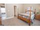 Comfortable bedroom with a four poster bed, neutral walls, and doorway access to another room at 482 N Jeff Davis Dr, Fayetteville, GA 30214