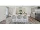 Open kitchen with a large island featuring seating, stainless steel appliances, and laminate floors at 5451 Baybrook Cir, South Fulton, GA 30349
