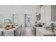 Modern kitchen features stainless steel appliances, gray cabinetry, and an island with barstool seating and laminate floors at 5451 Baybrook Cir, South Fulton, GA 30349