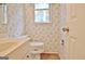 Small bathroom featuring a toilet, single sink vanity, and a window dressed in wallpaper at 212 Garret Rdg, Peachtree City, GA 30269